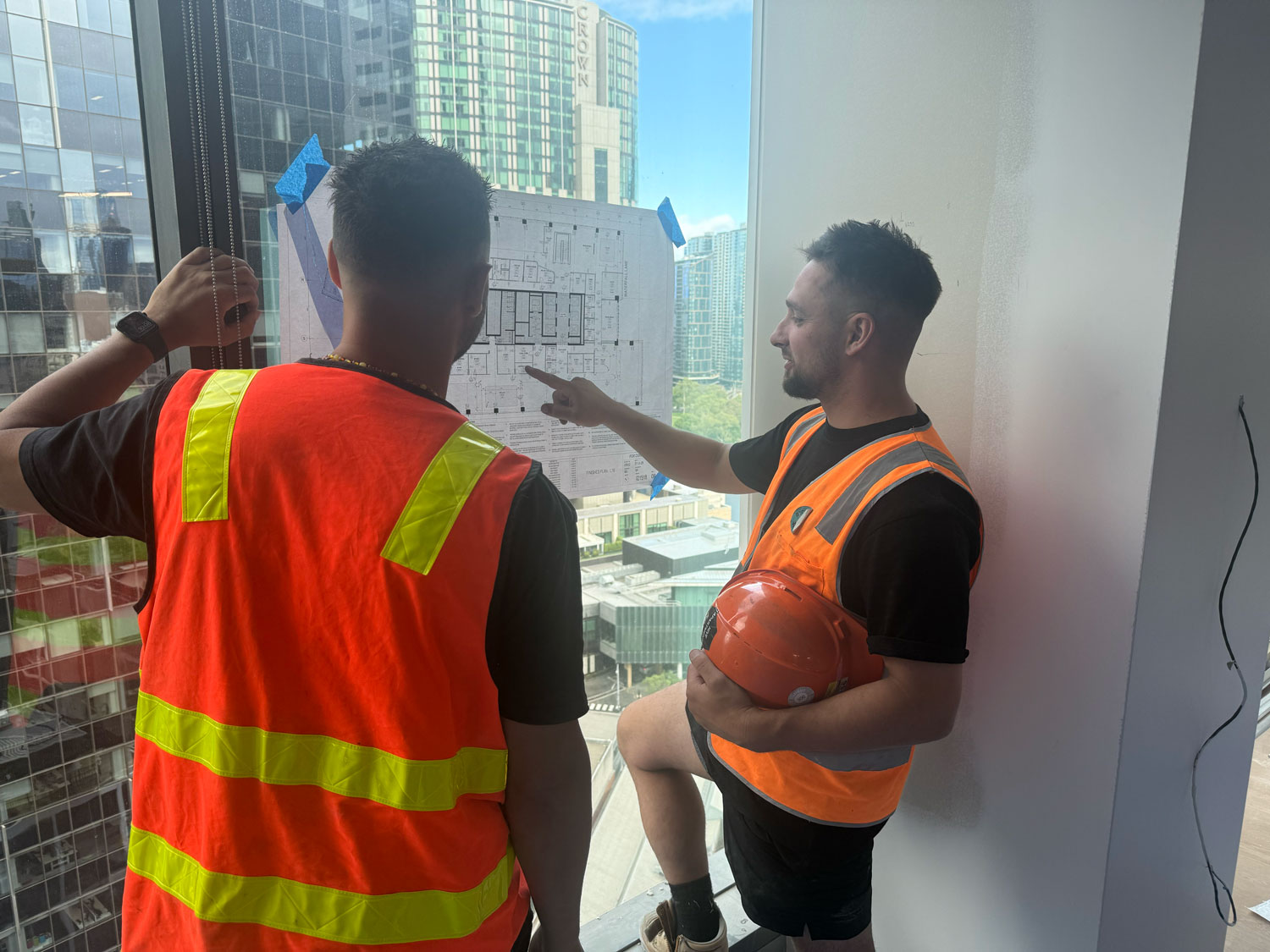 Installer reviewing site plans on a Melbourne project